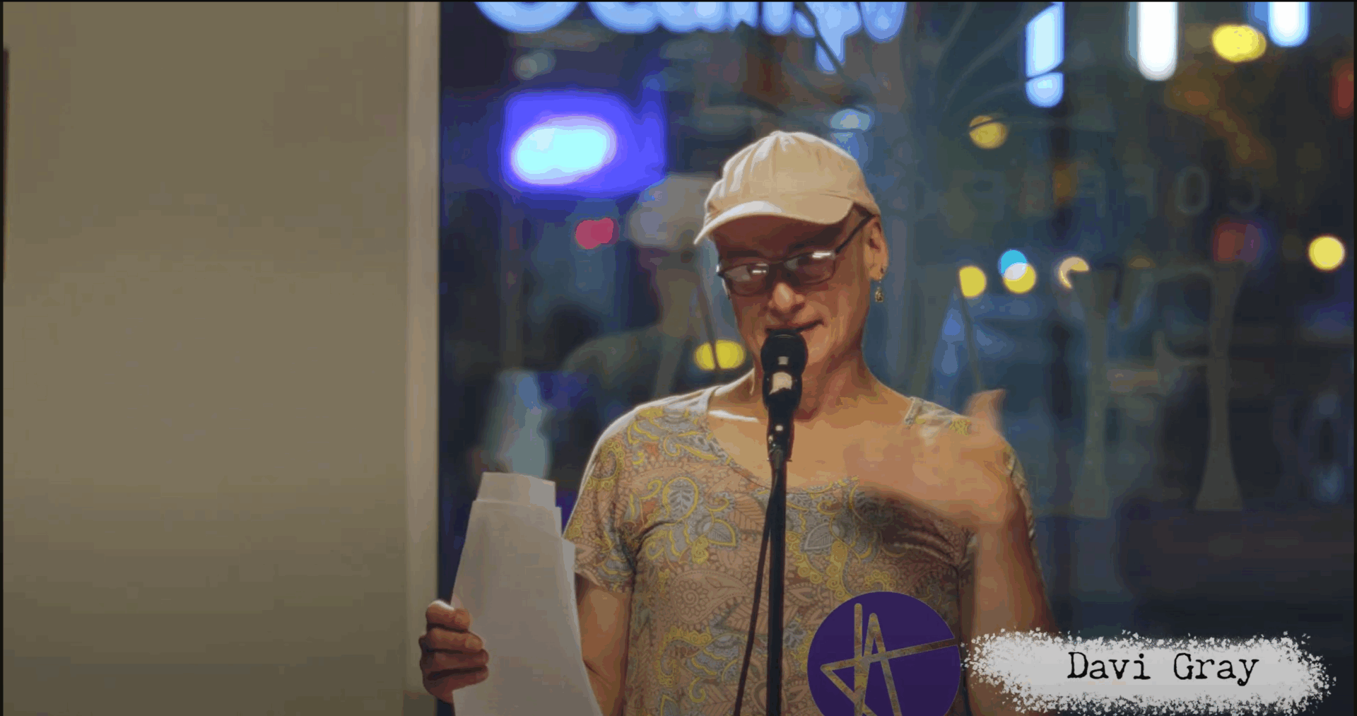 Photo of Davi Gray at Re-Verb Open Mic. Behind her, the window of Flava Cafe.